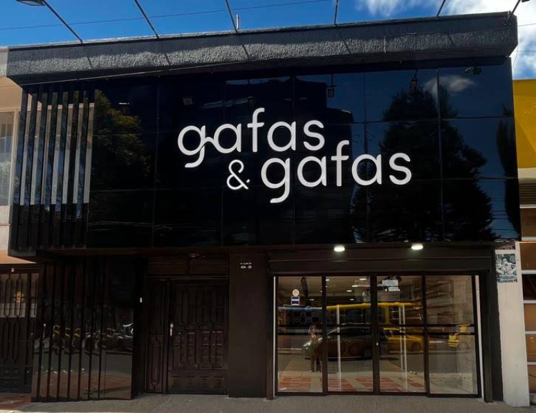 Storefront with a large black sign reading 'gafas & gafas' above a glass door entrance (eyewear shop)